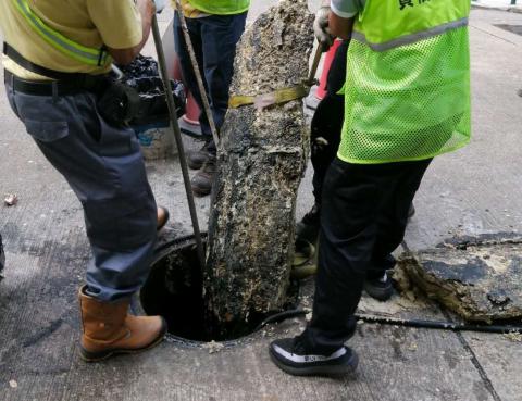 工作人员清理下水道油脂硬块
